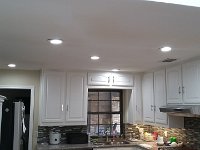 Here is the kitchen with the surface lights removed and can lights installed further from the upper cabinets so that light is projected on the work surfaces.