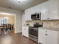 Here is the garage side of the kitchen after the remodel.  We raised the ceiling, added a walk in pantry where the wall oven was (door to the center left in the picture), and added all new cabinets, granite and backsplash.    All new appliances in the kitchen.